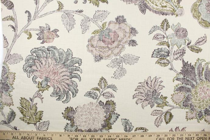  This fabric features a large print floral design in green, blue and purple on a cream background. 