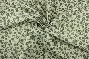 This jacquard fabric features small flowers in dark mauve on a light silver background. 