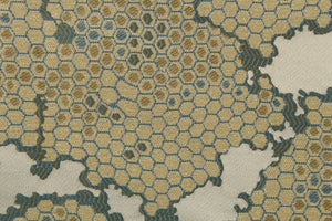 This fabric features a honeycomb design in a metallic gold, blue, and taupe .