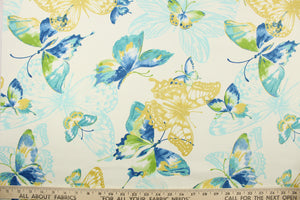 This fabric features a butterfly design in golden yellow, light turquoise blue, green, and blue set against a white background . 