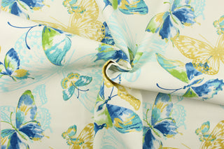 This fabric features a butterfly design in golden yellow, light turquoise blue, green, and blue set against a white background . 