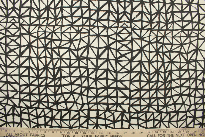 This fabric features a geometric design in black against a white background. 