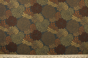 This fabric features a floral design in gold, brown, bronze and a dark rust orange with a latex backing. 