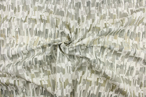 This fabric features an abstract design in gray beige, taupe, and white .