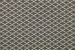 This fabric features a oval design in a cream, and shades of gray  with a latex backing.