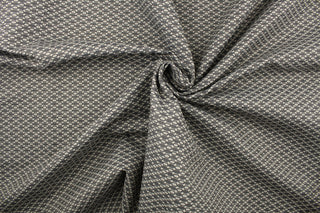 This fabric features a oval design in a cream, and shades of gray  with a latex backing.