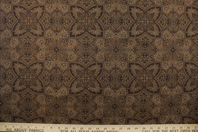 This fabric features a flower or butterfly design in brown, gold, tan, and beige with a latex backing . 