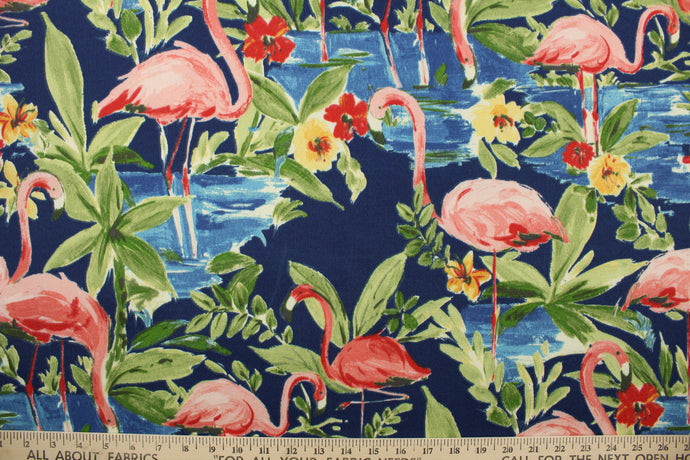  This outdoor fabric features a flamingo design in pink, red, green, blue, and yellow set against a navy blue background . 