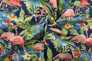  This outdoor fabric features a flamingo design in pink, red, green, blue, and yellow set against a navy blue background . 