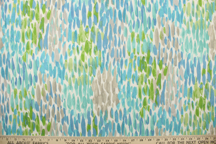 This outdoor fabric features a colorful design in turquoise, green, gray, blue and white . 