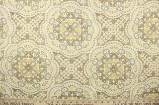 This  fabric features a medallion design in gray, taupe, yellow, and dull white .