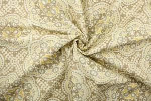 This  fabric features a medallion design in gray, taupe, yellow, and dull white .