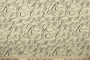  This fabric features cursive letters in black set against a beige background .