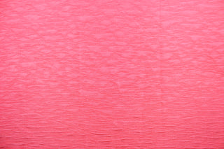 This taffeta fabric features a crinkle in a bright neon pink .