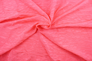 This taffeta fabric features a crinkle in a bright neon pink .