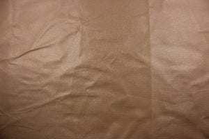 A vinyl fabric features a miniature brick design in a rich tan color.