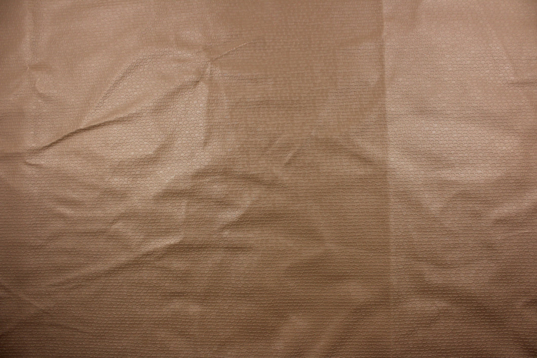 A vinyl fabric features a miniature brick design in a rich tan color.