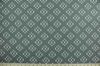 This screen printed outdoor fabric features a geometric design in white on a stone gray background.  It has a slightly stiff feel but easy to work with.  Solarium fabric will withstand up to 500 hours of sunlight, resists stains, water resistant and has a rating of 10,000 double rubs.  Perfect for porches, patios, and poolside.  Uses include toss pillows, cushions, upholstery, tote bags and more.