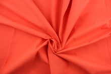 Load image into Gallery viewer, Poplin fabric in a solid orange. 
