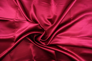 A beautiful satin fabric in a rich ruby red color.