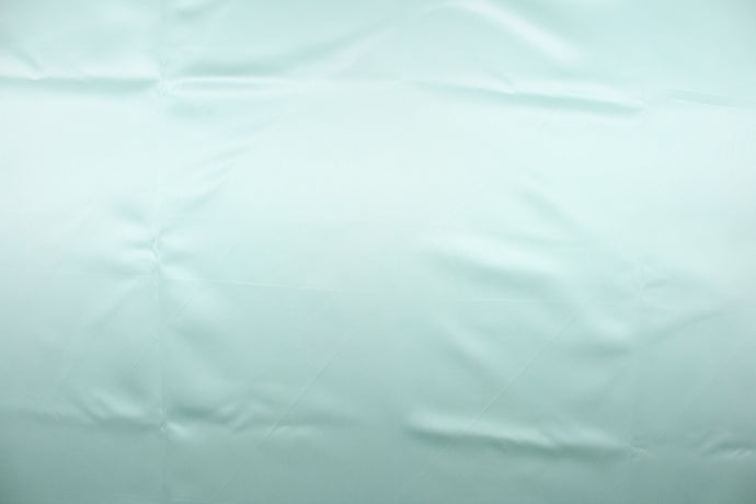 A beautiful satin fabric in a pale turquoise color.