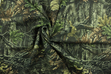 Load image into Gallery viewer, This camouflage fabric features realistic branches and leaves in various shades of green, brown and black against a hunter green background.  The fabric offers maximum concealment and is perfect for all open areas and is water repellant.  Uses include coveralls, pants, jackets, hats and bags.  We offer several different camouflage designs.
