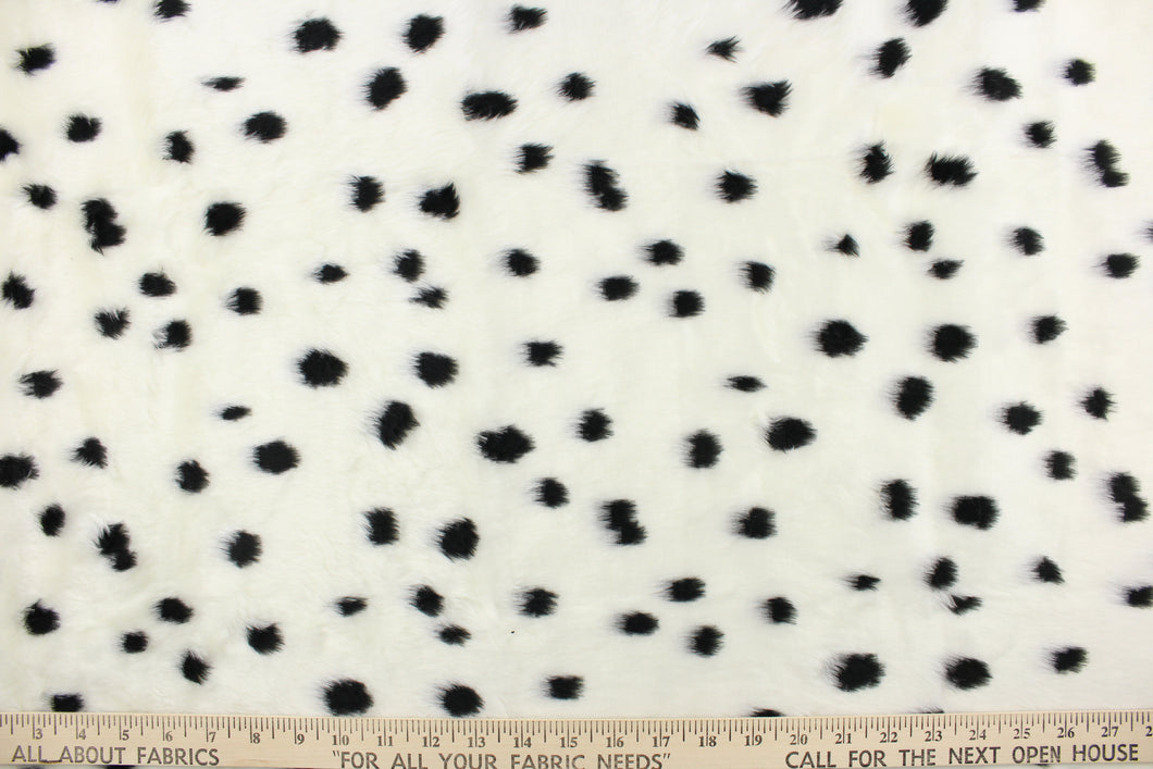 This faux fur features a dot design in black against white. 