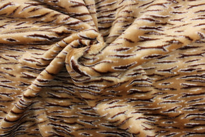 This faux fur features a  stripe design in brown, tan and hints of white . 