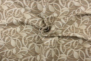 This fabric features a floral design in beige against a stripes in brown, orange, and gray. 