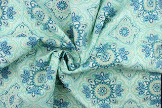 This outdoor fabric features a medallion design in blues, beige, white, turquoise, mint green, and pale green . 