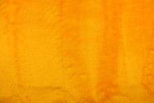 Load image into Gallery viewer,  A faux fur in a solid bright yellow with orange undertones.
