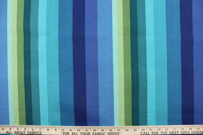This outdoor fabric features a stripe design in varying shades of blue, turquoise, lime green  . 