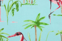 Load image into Gallery viewer, This outdoor fabric features a flamingo and tree design in green, pink, light brown, white and black against a light blue . 
