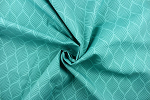 This outdoor fabric features a leaf design in shades of teal green. 