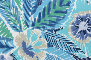 This outdoor fabric features a vibrant floral design in varying shades of blue, gray, black, green, and white.