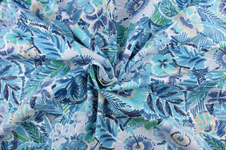 This outdoor fabric features a vibrant floral design in varying shades of blue, gray, black, green, and white.