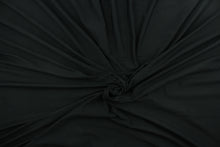 Load image into Gallery viewer, This black cotton jersey fabric, has a 4-way stretch that is soft, durable, breathable and will allow movements of the body.  Uses include t-shirts, sportswear, loungewear, leggings, children&#39;s apparel, bedding and sheets.  We offer a variety of jersey fabrics.
