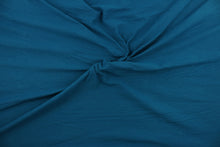 Load image into Gallery viewer, This turquoise cotton jersey fabric, has a 4-way stretch that is soft, durable, breathable and will allow movements of the body.  Uses include t-shirts, sportswear, loungewear, leggings, children&#39;s apparel, bedding and sheets.  We offer a variety of jersey fabrics.
