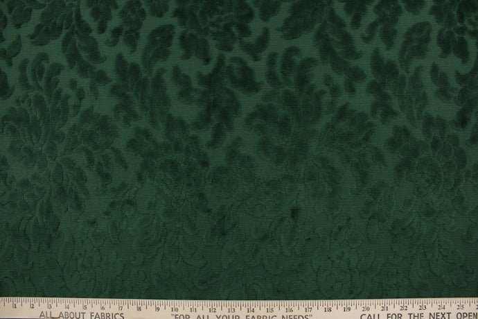 An upholstery velvet featuring a floral design in a rich green.