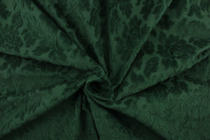 An upholstery velvet featuring a floral design in a rich green.