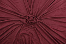 Load image into Gallery viewer, This burgundy cotton jersey fabric, has a 4-way stretch that is soft, durable, breathable and will allow movements of the body.  Uses include t-shirts, sportswear, loungewear, leggings, children&#39;s apparel, bedding and sheets.  We offer a variety of jersey fabrics.
