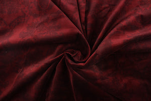This velvet features a demask design in a tone on tone deep red  with a latex backing.