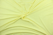 Load image into Gallery viewer, This lemon yellow, cotton jersey fabric, has a 4-way stretch that is soft, durable, breathable and will allow movements of the body.  Uses include t-shirts, sportswear, loungewear, leggings, children&#39;s apparel, bedding and sheets.  We offer a variety of jersey fabrics.
