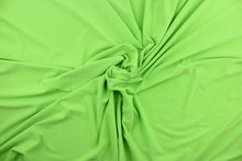 Load image into Gallery viewer, This lime green cotton jersey fabric, has a 4-way stretch that is soft, durable, breathable and will allow movements of the body.  Uses include t-shirts, sportswear, loungewear, leggings, children&#39;s apparel, bedding and sheets.  We offer a variety of jersey fabrics.
