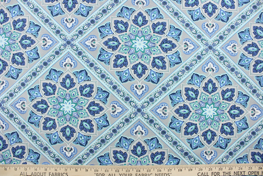 This outdoor print features a medallion design in blue, light blue, green, white, gray, and black  . 