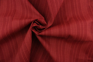 This Solarium outdoor decorative print features a duotone stripe design in berry.  This versatile, long-lasting fabric can withstand up to 500 hours of sunlight, water and stain resistant and has 10,000 double rubs.  It is perfect for lounge cushions, pool furniture, tablecloths, decorative pillows and upholstery projects.  This fabric has a slightly stiff feel but is easy to work with.  