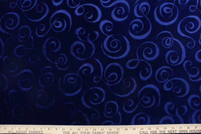A velvet featuring a swirl design in a tone on tone rich dark blue .