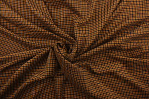 This velvet features a houndstooth plaid design in tan, black and brown  .