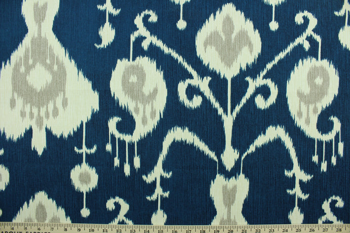 Java features an ikat design in pale gray and ivory on a navy blue  background.  It can be used for several different statement projects including window accents (drapery, curtains and swags), decorative pillows, cornice boards, bed skirts, duvet covers, upholstery and craft projects.  It has a soft workable feel yet is stable and durable with 17,000 double rubs. .
