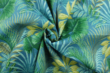 Load image into Gallery viewer, This fabric features large exotic tropical flowers and foliage in shades of teal, yellow, green, blue and brown.  It is perfect for outdoor settings or indoors in a sunny room.  It can withstand up to 500 hours of sunlight and is water and stain resistant and has a rating of 60,000 rubs.  Perfect for porches, patios and pool side.  Uses include toss pillows, cushions, upholstery, tote bags and more.  
